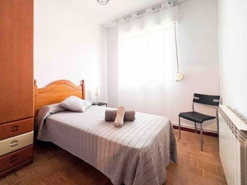 1 dormitorio con 1 cama, 1 silla y 1 ventana en Casa Yolanda, en Ávila
