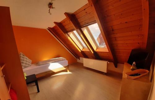 an attic room with a bed and a window at Apartmenthaus zum Birnbaum in Ansbach