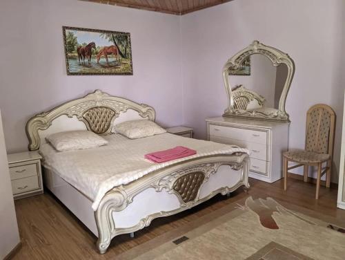 a bedroom with a white bed and a mirror at Жаркое лето на Иссык-Куле in Cholpon-Ata