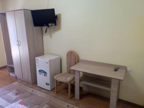 チョルポン・アタにあるЖаркое лето на Иссык-Кулеのテーブルと小型冷蔵庫付きの客室です。