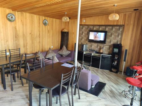 Zimmer mit einem Tisch, einem Sofa und einem TV in der Unterkunft Жаркое лето на Иссык-Куле in Tscholponata