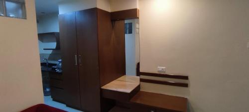 uma cozinha com armários castanhos e uma bancada em Happy Vibes studio flats - service apartment em Mysore