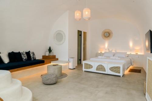 a white room with a bed and a couch at Three Bells Suites in Firostefani