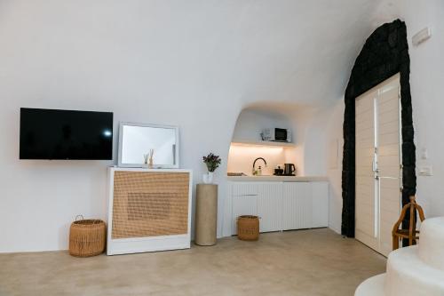 a living room with a television on a wall at Three Bells Suites in Firostefani