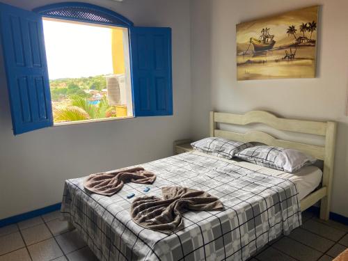 Un dormitorio con una cama con una manta. en Pousada Lavramor, en Lençóis