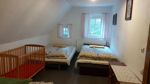 a bedroom with two beds and a crib at Domek z duszą in Szklarska Poręba