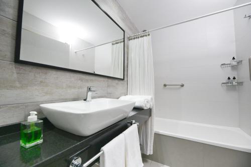 a white bathroom with a sink and a shower at Monoambiente Recoleta in Buenos Aires