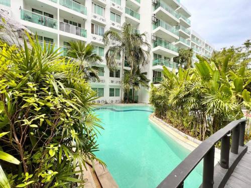a swimming pool in front of a building at EXCESSIVELY 1 Bedroom in Amazon Condo in Jomtien Beach