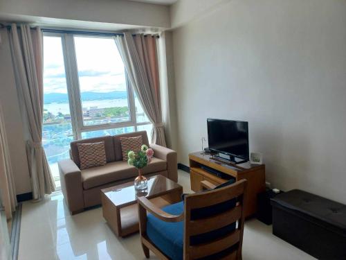a living room with a couch and a television at CONDO-Mactan NewTown in Mactan