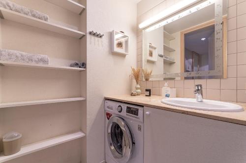 a bathroom with a washing machine and a sink at HYGGE APART with fireplace at the seaside in Kuressaare