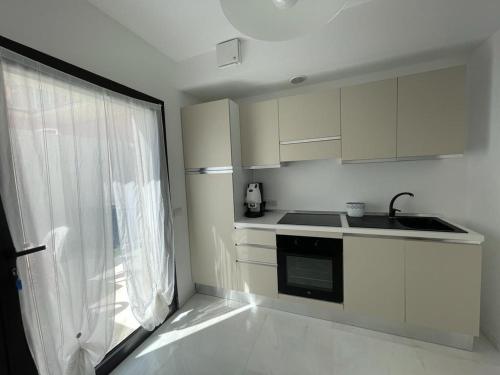 a white kitchen with a sink and a window at Crystal in Santo Stefano al Mare