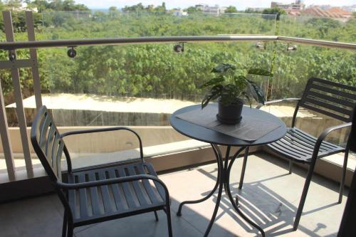 a table and chairs on a balcony with a potted plant at family vacation accomodation in Maribago