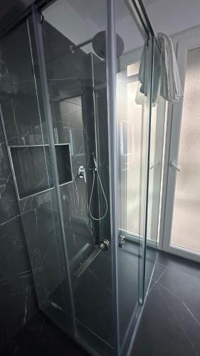 y baño con ducha y puerta de cristal. en Sole apartments, en Shëngjin
