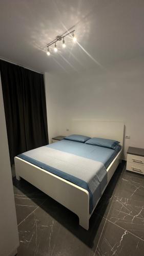 a bedroom with a large bed with blue sheets at Sole apartments in Shëngjin