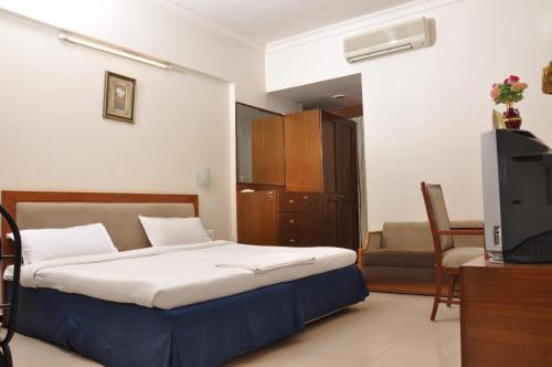 a bedroom with a bed and a tv in it at Hotel Sitara Residency in Hyderabad