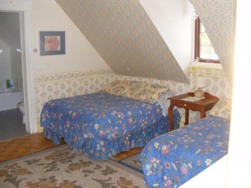 サン・ガブリエル・ド・ヴァルカルティエにあるAuberge La Seigneurie Valcartierの小さなベッドルーム(ベッド2台、テーブル付)