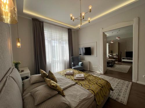 Visit Debrecen Apartman في ديبريتْسين: غرفة نوم مع سرير وغرفة معيشة