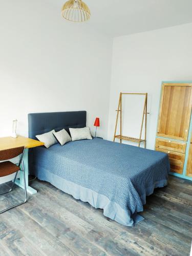 - une chambre avec un lit bleu et du parquet dans l'établissement Chez Leslie et Vincent : logements climatisés avec parking privatif, à Perpignan