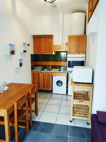 une cuisine avec des armoires en bois et une table en bois dans l'établissement Chez Leslie et Vincent : logements climatisés avec parking privatif, à Perpignan