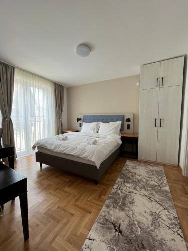 sypialnia z łóżkiem, biurkiem i kanapą w obiekcie Vila Simfonija w mieście Vrnjačka Banja
