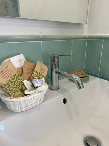 ein Waschbecken mit einem Korb mit Handtüchern und einem Wasserhahn in der Unterkunft MIRAMA’ in Maiori