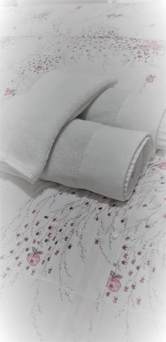 Una cama blanca con flores rosas. en Mia DM Apartment, en Skopje