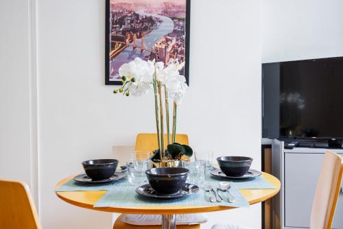 a dining room table with plates and bowls on it at One Bedroom Near Russell Square in London