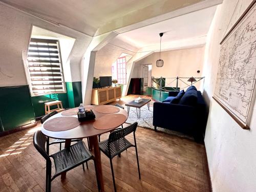 een woonkamer met een tafel en stoelen en een bank bij Appartement Centre ville Le blanc in Le Blanc