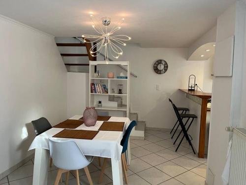een keuken en eetkamer met een tafel en een kroonluchter bij Petite maison de ville au calme in Brie-Comte-Robert