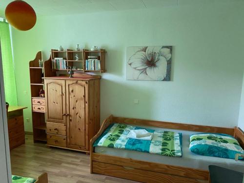 ein Schlafzimmer mit einem Bett und einer Holzkommode in der Unterkunft Apartment Hannover Messe in Hannover