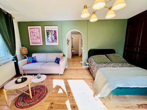um quarto com uma cama e um sofá em Appartement « Dolce Vita » em Vitry-le-François