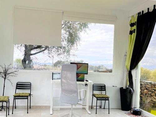 a room with a desk and chairs and a window at El Coso Lodge & Workation in Zalamea la Real