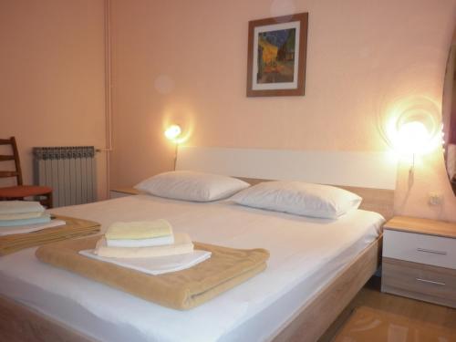 a bedroom with a white bed with towels on it at Apartments Gojka Miocevic in Biograd na Moru