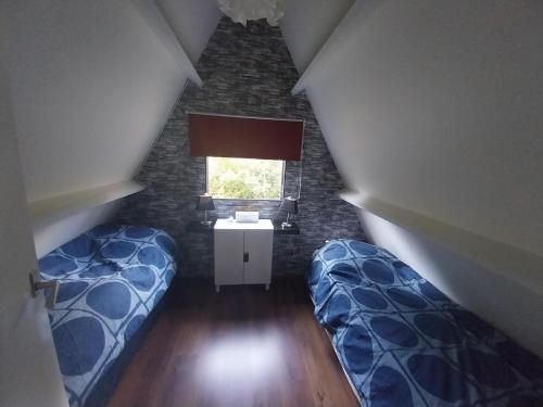 Zimmer im Dachgeschoss mit 2 Betten und einem Fenster in der Unterkunft Het Uilennest in Durbuy in Durbuy