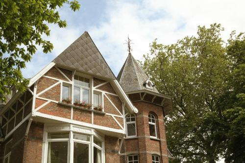 a brick house with a tower with a window at B&B Villa Emma in Ghent