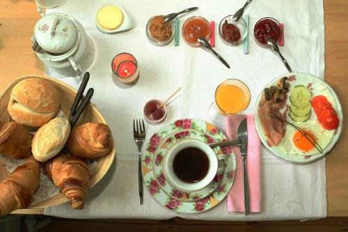 a table with a plate of food and a cup of coffee at B&B Villa Emma in Ghent
