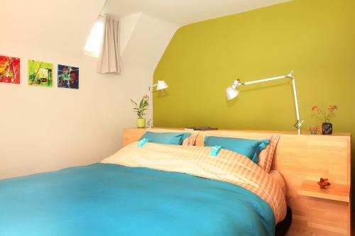 a bedroom with a blue bed and a green wall at B&B Villa Emma in Ghent