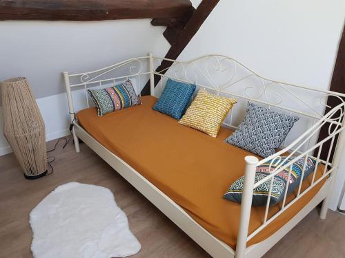 ein Bett mit Kissen darauf in einem Zimmer in der Unterkunft La Chaumière de Chabine in Oizon