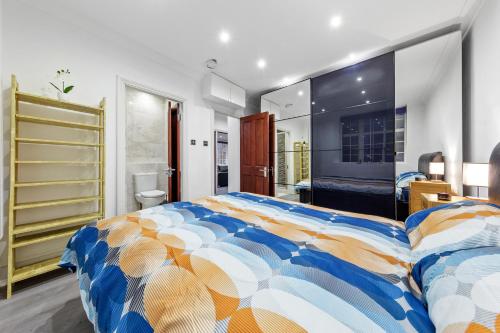 a bedroom with a large bed with a colorful comforter at Luxury Flat in London - Mayfair in London