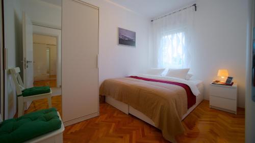 a white bedroom with a bed and a window at Luxe 3BR Apartment Split in Split