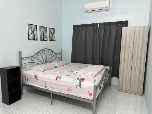 En eller flere senge i et værelse på Guan Homestay Sungai Besar 大港民宿