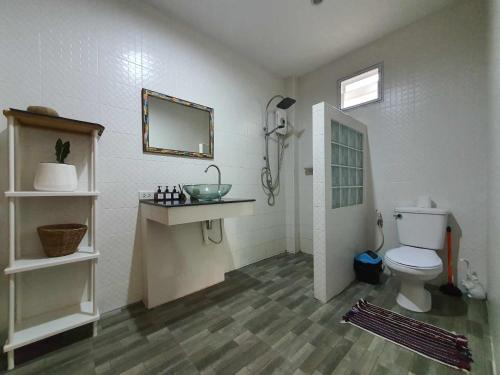 a bathroom with a toilet and a sink and a mirror at Niniari House in Thong Sala