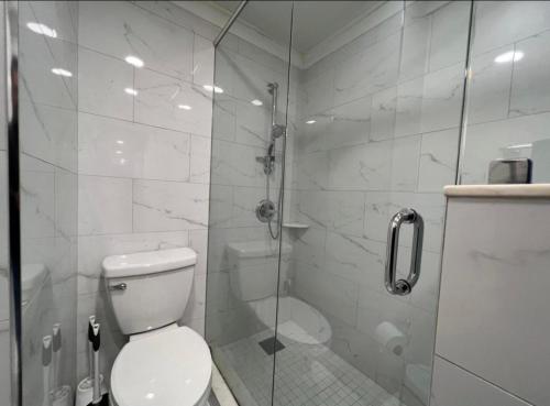 een badkamer met een toilet en een glazen douche bij Cozy Haven in the Clouds in Atlanta