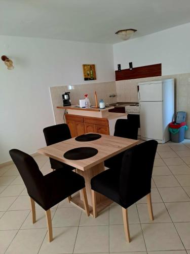 a kitchen with a wooden table and black chairs at Apartman Donna in Zaboric