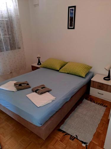 a bedroom with a bed with two towels on it at Apartman Donna in Zaboric