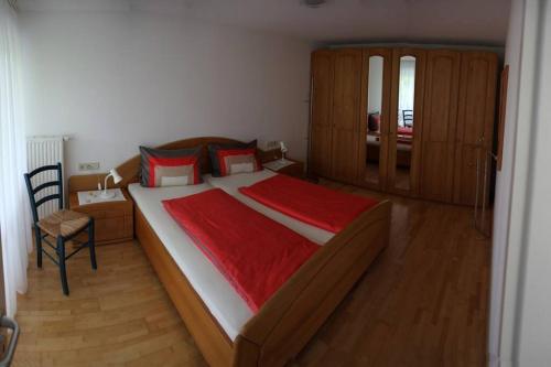 1 dormitorio con 1 cama grande con manta roja en Ferienwohnung Krüger, en Owingen