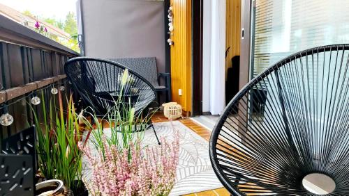 twee zwarte stoelen op een balkon met bloemen bij Ferienwohnungen Krüger ''Apartment Finn" in Michelstadt