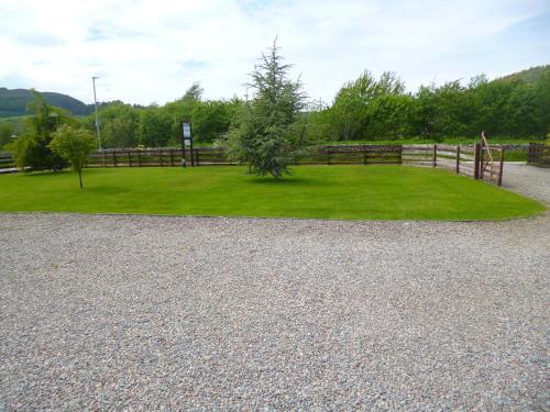 a park with a fence and a grass field at Aslaich in Drumnadrochit