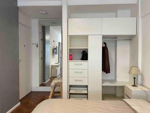 a bedroom with a bed and a closet with a mirror at Studio Palermo Hermoso Con Balcon in Buenos Aires