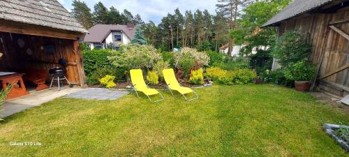 three yellow chairs sitting in a yard at Siedlisko pod lipą in Józefów
